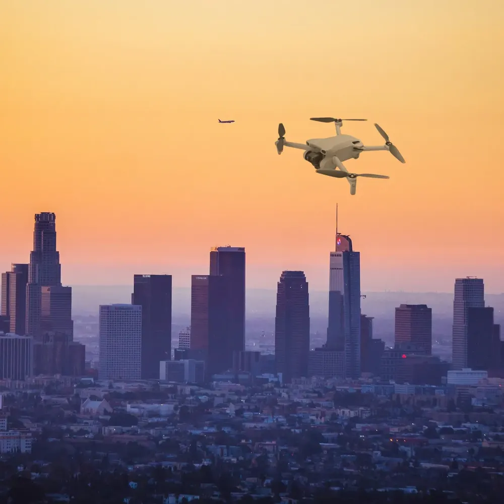DJI Mini 3 against a city skyline at dusk (composite image)