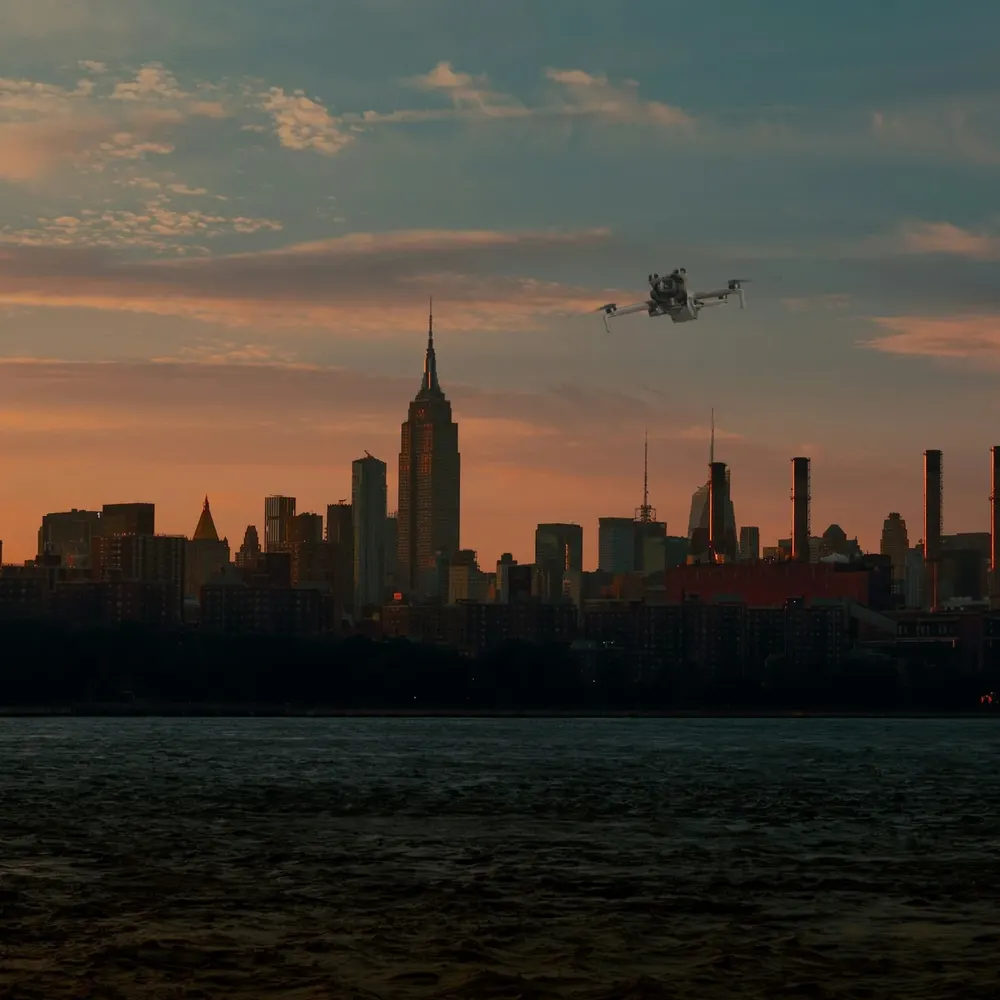 DJI Mini 5 Pro against the New York skyline at sunset (composite image)