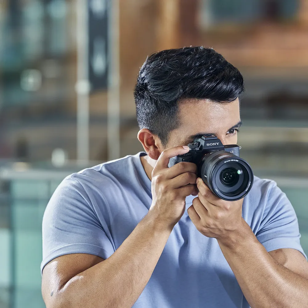 Sony Alpha 7 IV body, photographer shooting, official Sony image